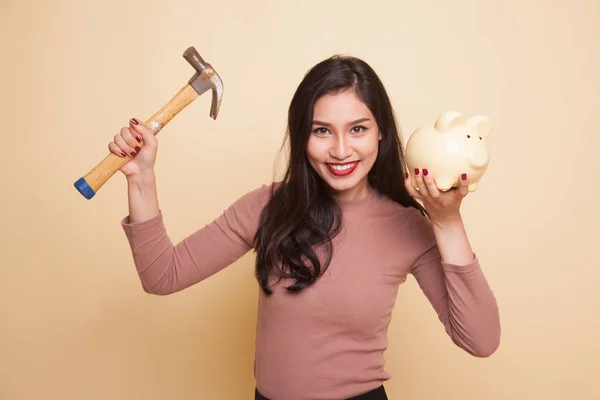 Mulher asiática com banco de moedas de porco e martelo . — Fotografia de Stock