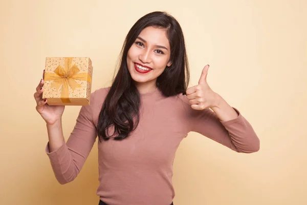 亚洲女人竖起大拇指与一个礼品盒. — 图库照片