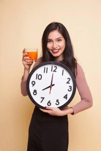 Femme asiatique avec une horloge boisson jus d'orange . — Photo