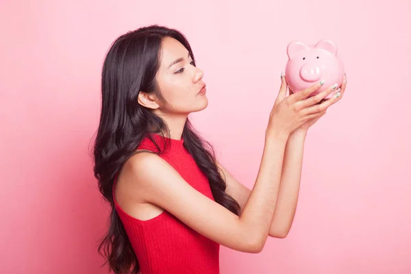 Young Asian woman kiss  a pink coin bank. — Stock Photo, Image