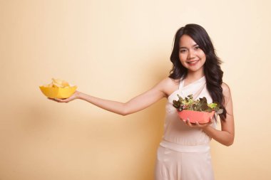 Patates kızartması ve salata ile genç Asyalı kadın.