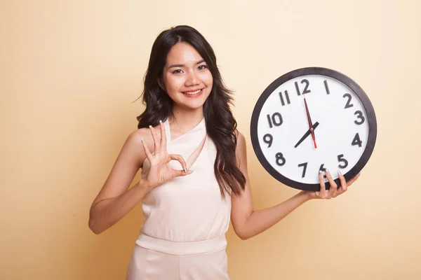 Joven asiática show OK con un reloj . —  Fotos de Stock