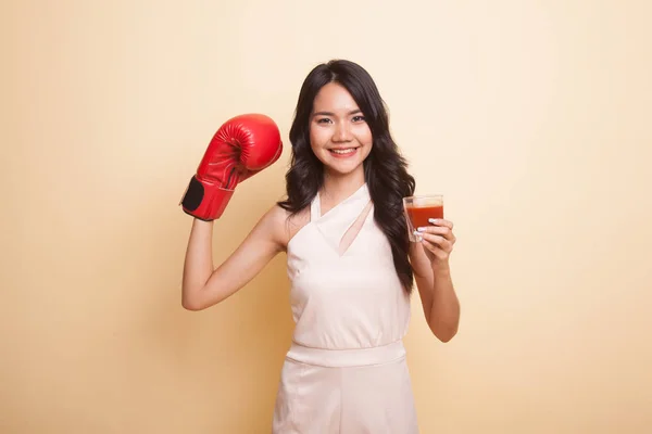 Jeune femme asiatique avec jus de tomate et gant de boxe . — Photo