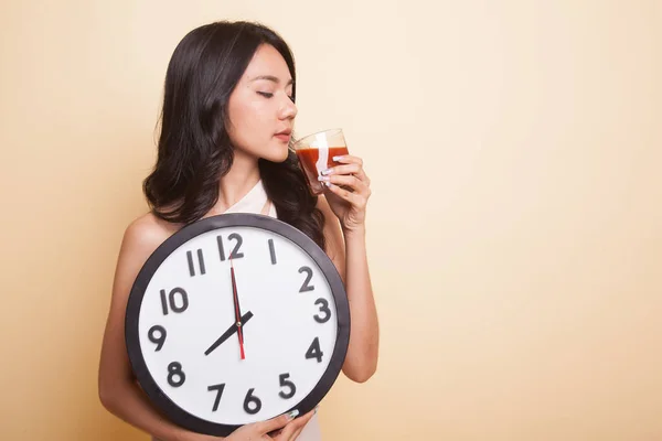 Jeune femme asiatique avec du jus de tomate et horloge . — Photo