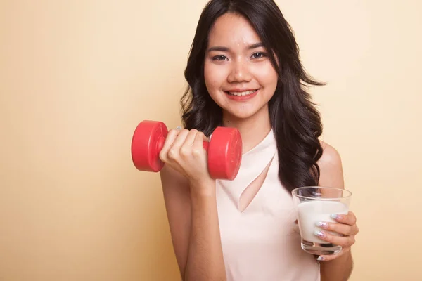 Friska asiatisk kvinna dricka ett glas mjölk och hantel. — Stockfoto