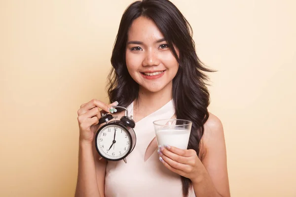 Saludable mujer asiática bebiendo vaso de leche celebrar reloj . — Foto de Stock