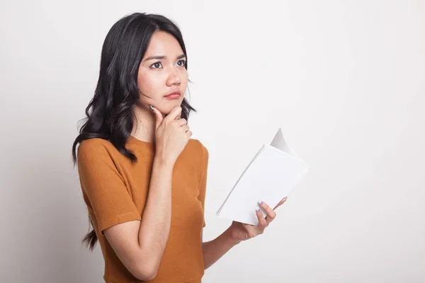 Giovane donna asiatica con un libro sta pensando . — Foto Stock