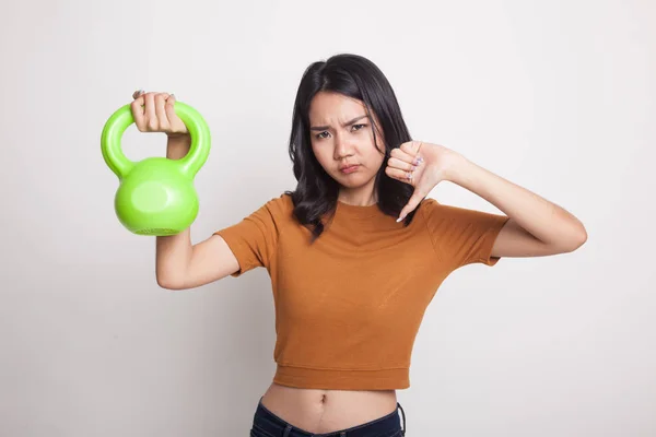 Unhappy Asian woman thumbs down with dumbbells.