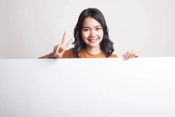 Jonge Aziatische vrouw overwinning teken met leeg teken weergeven. — Stockfoto