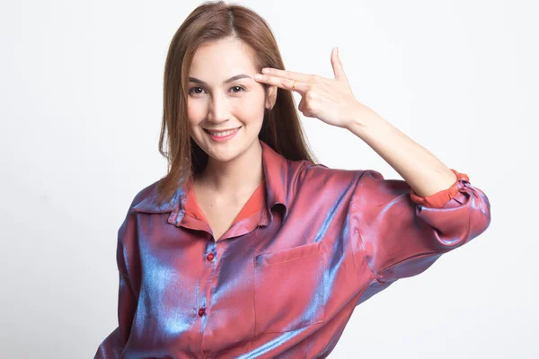 Beautiful young Asian woman holding fingers in gun gesture. — Stock Photo, Image