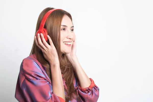 Bonita chica asiática escuchando música con sus auriculares . — Foto de Stock