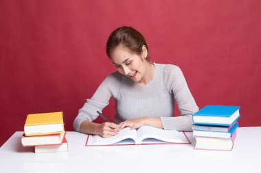 Genç Asyalı kadın kitapları tablo ile bir kitap okumak.