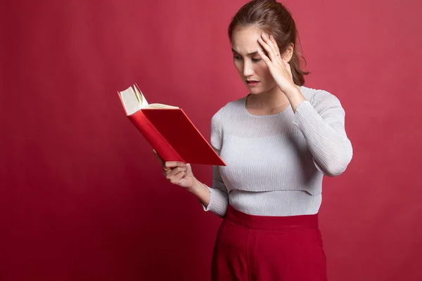 Joven asiática mujer got headache leer un libro . — Foto de Stock