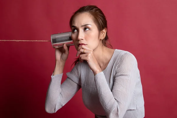 Joven mujer asiática escuchando con lata puede teléfono y pensando . —  Fotos de Stock