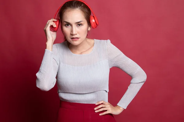 Too loud.  portrait of  young asian woman  holding  headphones a