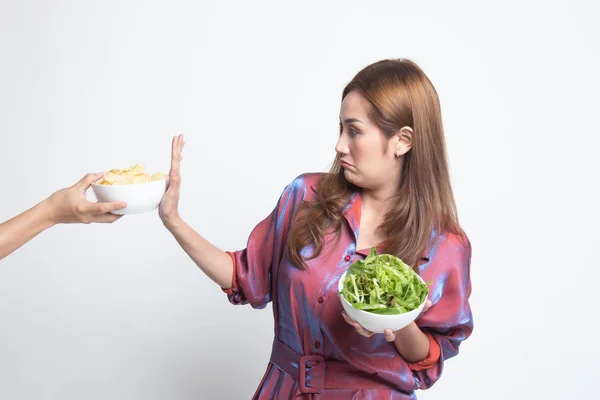 Jonge Aziatische vrouw met salade nee zeggen tegen potato chips. — Stockfoto