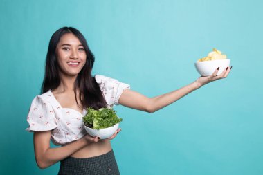 Patates kızartması ve salata ile genç Asyalı kadın.