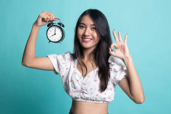 Mladá asijská žena Ukázat Ok s hodinami. — Stock fotografie