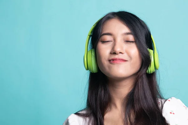 Bonita chica asiática escuchando música con sus auriculares . — Foto de Stock