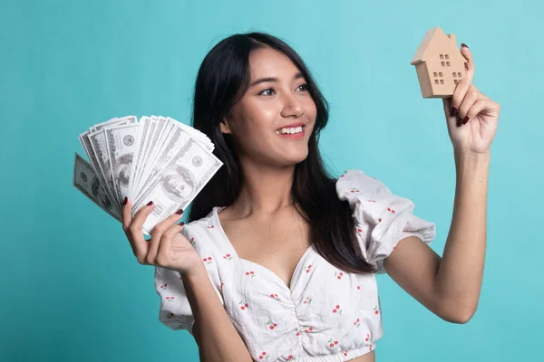 Šťastný mladý asijské žena s dům modelu a spoustu peněz banka — Stock fotografie