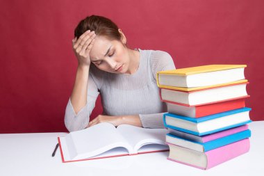 Yorgun Asyalı kadın baş ağrısı okuma sekmesinde kitaplarla bir kitap aldım.