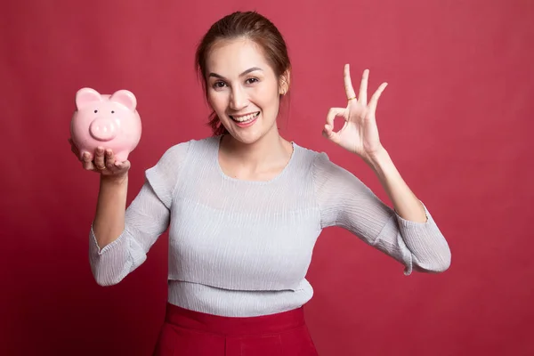 Asiática mujer espectáculo OK con cerdo moneda banco . —  Fotos de Stock