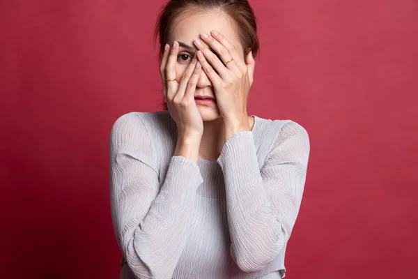 Vacker ung asiatisk kvinna kikar genom fingrarna. — Stockfoto