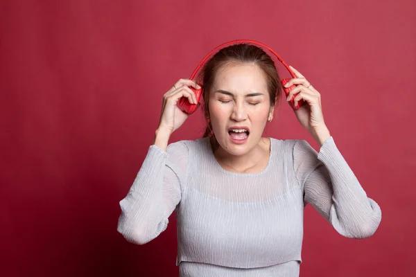 Demasiado fuerte. retrato de joven asiática mujer sosteniendo auriculares un —  Fotos de Stock