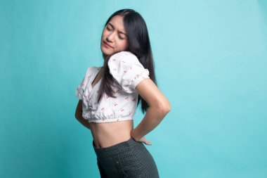  Genç Asyalı kadının arka planda siyan rengi sırtı ağrıyormuş.