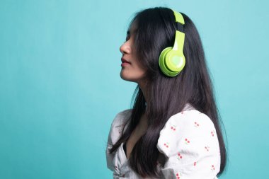 Güzel Asyalı kız kulaklıklarıyla müzik dinliyor..