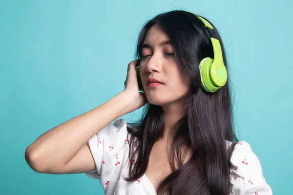 Bonita chica asiática escuchando música con sus auriculares . — Foto de Stock