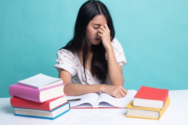 Yorgun Asyalı kadın baş ağrısı okuma sekmesinde kitaplarla bir kitap aldım.