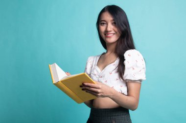 Genç Asyalı kadın Cyan geçmişi hakkında bir kitap okudu.