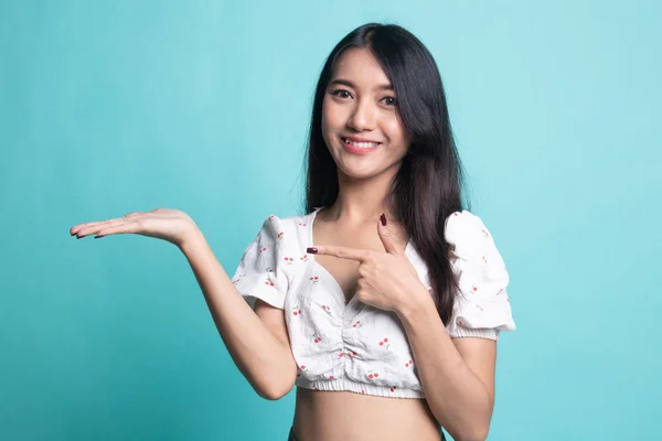 Kaunis nuori aasialainen nainen osoittaa kämmenelle . — kuvapankkivalokuva