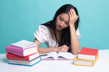 Yorgun genç Asyalı kadın kitapları tablo ile bir kitap okumak.