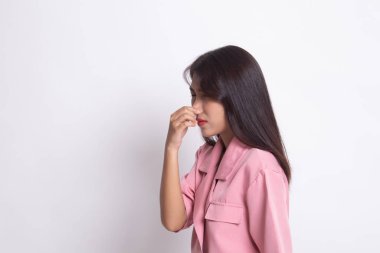 Kötü bir koku yüzünden burnunu tutan genç Asyalı kadın.