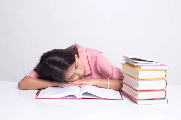 Utmattad ung asiatisk kvinna sömn med böcker på bord. — Stockfoto