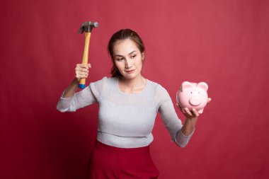 Asyalı kadın domuz para banka ve çekiç ile.