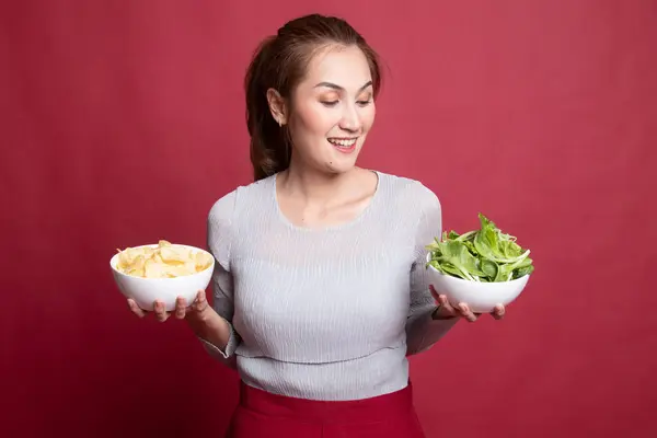 Jonge Aziatische vrouw met aardappel frites en salade. — Stockfoto