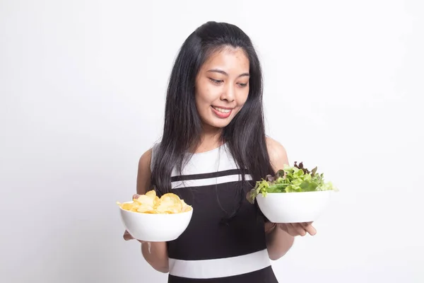 Ung asiatisk kvinna med potatischips och sallad. — Stockfoto