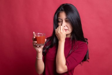 Genç Asyalı kadın nefret domates suyu.