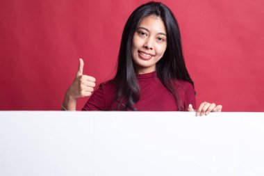 Genç Asyalı kadın ortaya başparmak boş işaretiyle.