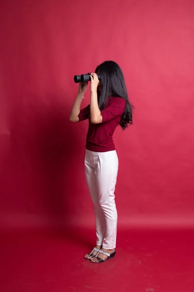 Full body of young Asian woman with binoculars.