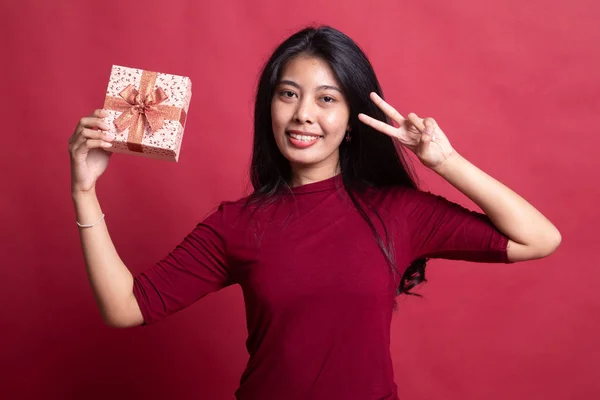 Giovane donna asiatica mostra segno di vittoria con una scatola regalo . — Foto Stock