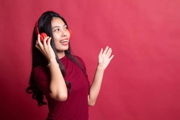 Красивая азиатская девушка слушает музыку в наушниках . — стоковое фото