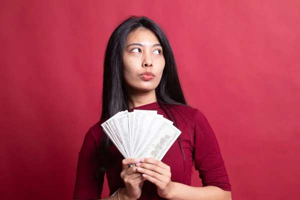 Portrét mladé asijské ženy ukazující hromadu bankovek — Stock fotografie