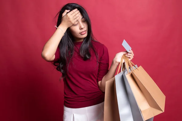 Olycklig ung asiatisk kvinna med påsar och kreditkort. — Stockfoto