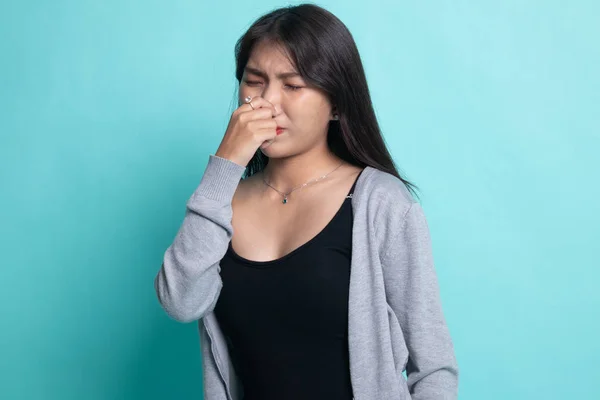 Joven asiática sosteniendo su nariz debido a un mal olor . —  Fotos de Stock