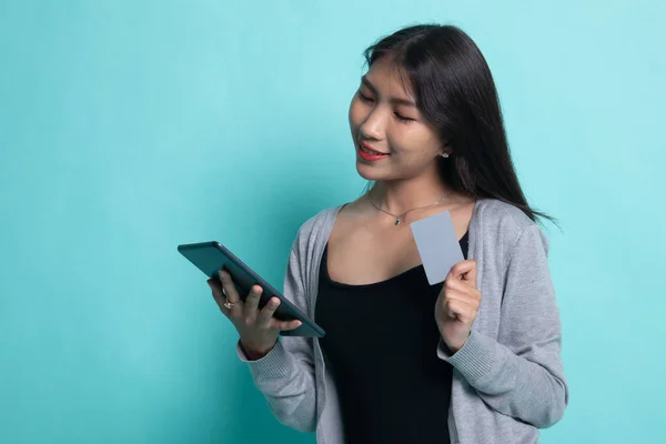 Jeune femme asiatique est shopping en ligne avec carte de crédit et tablette — Photo