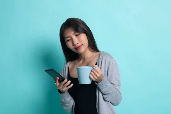 Jeune femme asiatique avec téléphone mobile et tasse de café . — Photo